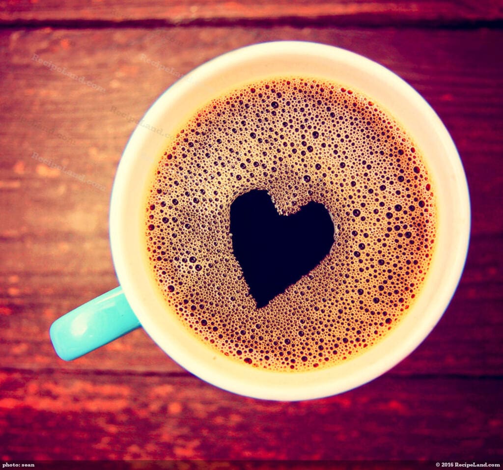 A cup of coffee with a heart shaped cut out.