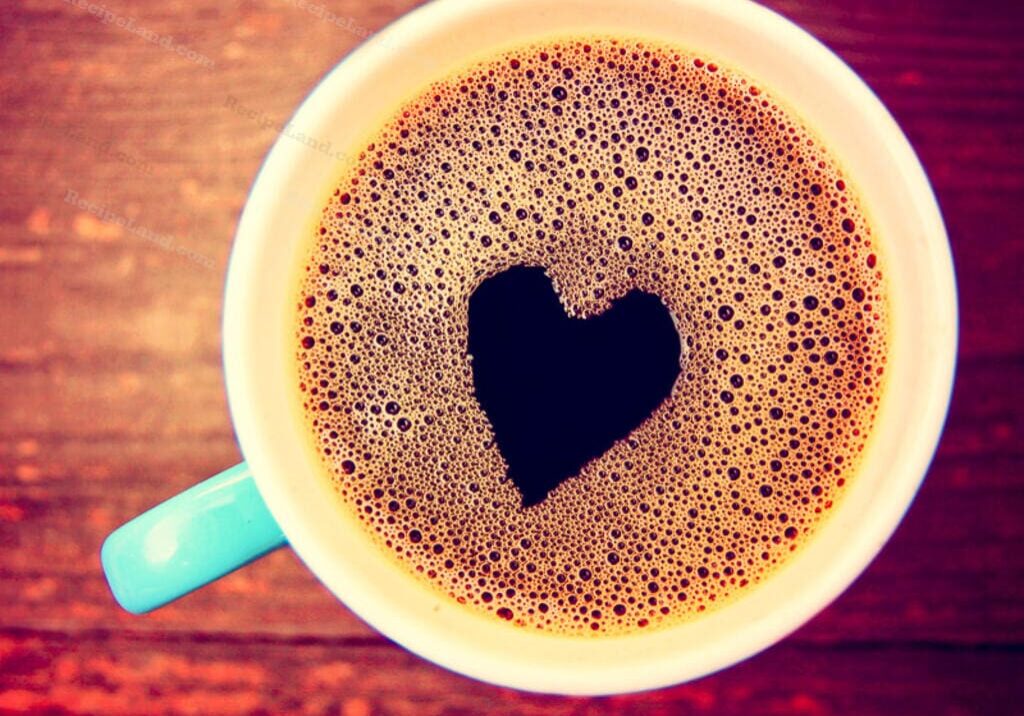 A cup of coffee with a heart shaped cut out.