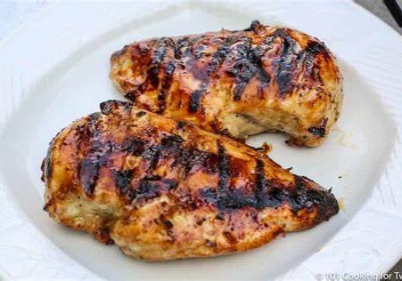 Two grilled chicken breasts on a plate.